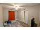 Cozy bedroom with neutral paint, ceiling fan, closet and a window with orange curtain at 624 N Lanier Ave, Fort Meade, FL 33841