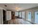Bright living room with wood-look floors, ceiling fan, and natural light from windows and glass doors at 624 N Lanier Ave, Fort Meade, FL 33841