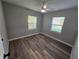 Bright bedroom with two windows, neutral paint, ceiling fan, and luxury vinyl plank flooring at 631 Julia Se St, Winter Haven, FL 33880