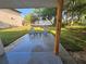 Covered back patio with two gray chairs and table overlooking the green yard at 631 Julia Se St, Winter Haven, FL 33880