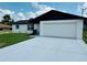Charming home featuring a freshly painted exterior, a two-car garage, and a well-maintained front yard under a blue sky at 655 E Sanford St, Lake Alfred, FL 33850