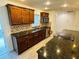 Modern kitchen with granite countertops, stainless steel appliances, stylish backsplash, and ample storage in dark wood cabinets at 655 E Sanford St, Lake Alfred, FL 33850