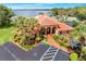 Aerial view of the clubhouse featuring a red tiled roof, landscaping, and parking at 703 Magnolia Pl # 703, Winter Haven, FL 33884