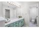 Bathroom featuring a marble countertop, seafoam green cabinets, and a large mirror with vanity lighting at 703 Magnolia Pl # 703, Winter Haven, FL 33884