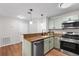 Galley kitchen featuring granite countertops, stainless steel appliances, and wood floors at 703 Magnolia Pl # 703, Winter Haven, FL 33884