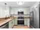 Galley kitchen featuring granite countertops, stainless steel appliances, and wood floors at 703 Magnolia Pl # 703, Winter Haven, FL 33884