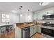 Virtually staged galley kitchen featuring granite countertops, stainless steel appliances, and wood floors at 703 Magnolia Pl # 703, Winter Haven, FL 33884