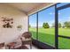 View of the screened-in patio with a wicker chair and a picturesque outdoor view at 703 Magnolia Pl # 703, Winter Haven, FL 33884