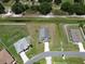 Aerial view of a home with a long driveway, fenced-in yard, and nearby pond at 830 Cabaret Ct, Kissimmee, FL 34759