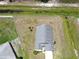 Aerial view showcasing a gray roof, long driveway, and fenced yard at 830 Cabaret Ct, Kissimmee, FL 34759