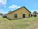 A well-maintained backyard with green grass and a view of the home's exterior at 830 Cabaret Ct, Kissimmee, FL 34759