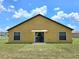 Exterior view of a home's backyard with lush green lawn and blue sky at 830 Cabaret Ct, Kissimmee, FL 34759