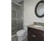 A bathroom features a stand up shower with sliding glass doors, and a vanity with granite countertops at 830 Cabaret Ct, Kissimmee, FL 34759