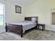 A bedroom features neutral colored walls, a nice wooden frame bed, and a window to allow natural light into the room at 830 Cabaret Ct, Kissimmee, FL 34759