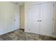 A bedroom with carpeting, neutral colored walls, and two doors that provide access to other areas of the house at 830 Cabaret Ct, Kissimmee, FL 34759