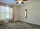 A bedroom with carpeting, neutral colored walls, and a window that provides natural light into the room at 830 Cabaret Ct, Kissimmee, FL 34759
