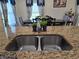 Close-up of a kitchen sink with granite countertops and a view of the dining area at 830 Cabaret Ct, Kissimmee, FL 34759