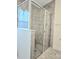 The tiled glass shower features a neutral color scheme and a view through the window from the bathroom at 830 Cabaret Ct, Kissimmee, FL 34759