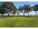 Expansive backyard with well-maintained lawn and waterfront view lined with trees at 8314 W Lake Marion Rd, Haines City, FL 33844