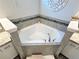 Bathroom features corner soaking tub and white vanity with granite countertop at 832 Vienna Dr, Winter Haven, FL 33884