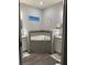 This is a view of the tub in the main bathroom, which features gray tile and light-colored cabinets at 832 Vienna Dr, Winter Haven, FL 33884