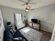 Well-lit bonus room with a comfortable couch, TV, storage bench and a ceiling fan at 832 Vienna Dr, Winter Haven, FL 33884