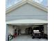 Spacious two car garage featuring ample storage space with shelving, ladder, and yard tools at 832 Vienna Dr, Winter Haven, FL 33884