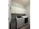 Convenient laundry room equipped with modern washer, dryer, and ample overhead storage at 832 Vienna Dr, Winter Haven, FL 33884