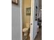 Efficient powder room design with a toilet, decorative picture and a charming throw basket at 832 Vienna Dr, Winter Haven, FL 33884