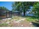 A lush backyard includes a screened-in pool area, rock landscaping, and mature shade trees at 961 Oleander Se Dr, Winter Haven, FL 33880