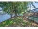 A spacious backyard features a screened-in pool, lush foliage, privacy fence, and mature trees at 961 Oleander Se Dr, Winter Haven, FL 33880