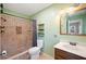 Bathroom with a tiled shower, wooden vanity, white toilet, and green walls at 961 Oleander Se Dr, Winter Haven, FL 33880