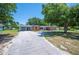 Traditional brick home with a long driveway, mature trees, and a well-maintained lawn at 961 Oleander Se Dr, Winter Haven, FL 33880
