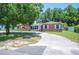 Attractive brick home featuring a lush front yard with mature trees and a well-paved driveway at 961 Oleander Se Dr, Winter Haven, FL 33880