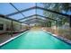 An inviting in-ground pool is enclosed with a screened-in structure with access ladder and diving board at 961 Oleander Se Dr, Winter Haven, FL 33880
