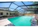 A sunny screened-in pool has an expansive deck, swimming ladder, and patio area with outdoor seating at 961 Oleander Se Dr, Winter Haven, FL 33880