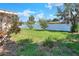 Green backyard featuring mature trees and a white fence at 961 Piedmont Se Dr, Winter Haven, FL 33880