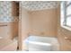 This bathroom features a tub and toilet with a decorative wallpaper border at 961 Piedmont Se Dr, Winter Haven, FL 33880
