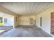 Spacious carport featuring ample storage cabinets, access door, and water heater at 961 Piedmont Se Dr, Winter Haven, FL 33880