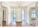 The home's front entrance showcases decorative sidelights, tiled floors, and a vintage light fixture at 961 Piedmont Se Dr, Winter Haven, FL 33880