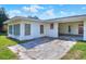 Home exterior features a sunny Florida room, access door, and connected carport at 961 Piedmont Se Dr, Winter Haven, FL 33880