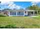 Home exterior boasts lush green lawns, a bright Florida room, and a spacious carport at 961 Piedmont Se Dr, Winter Haven, FL 33880