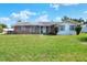 Charming single-story home with a brick facade and well-maintained front lawn and a lush green lawn at 961 Piedmont Se Dr, Winter Haven, FL 33880