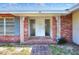 Close up of the front porch with brick columns, decorative ironwork, and a tiled walkway at 961 Piedmont Se Dr, Winter Haven, FL 33880
