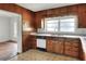 Original kitchen features wood cabinets, formica countertops, and a view to the adjacent space at 961 Piedmont Se Dr, Winter Haven, FL 33880