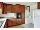 Practical kitchen with natural wood cabinets, appliances, and a convenient laundry area at 961 Piedmont Se Dr, Winter Haven, FL 33880