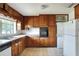 Cozy kitchen equipped with vintage wood cabinetry, and essential appliances at 961 Piedmont Se Dr, Winter Haven, FL 33880