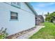 Exterior side view of home with window, sidewalk, and glimpses of screened patio at 109 Dakota Ave, St Cloud, FL 34769