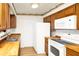Well-lit kitchen featuring wooden countertops, white appliances, and plenty of cabinetry at 109 Dakota Ave, St Cloud, FL 34769