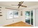 Bright sunroom with ceiling fan, built-in shelves, and access to the outdoor lanai at 109 Dakota Ave, St Cloud, FL 34769